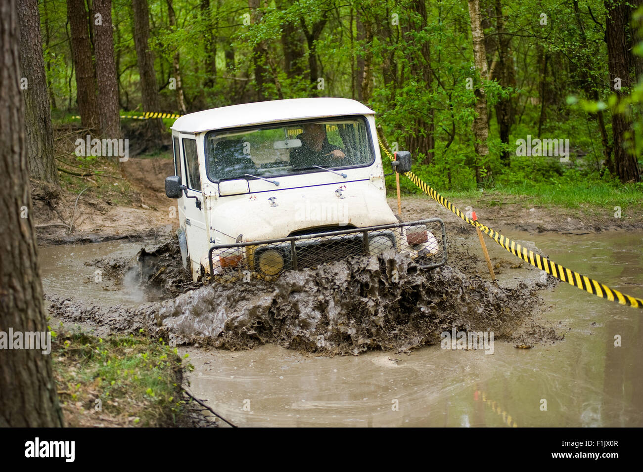 A jeep is driving through a pond of water on a special off the road terrain for land cruisers