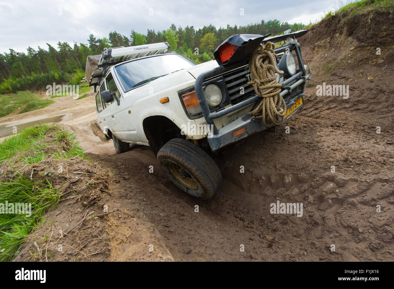 A Toyota 4-wheel drive is driving on a special off the road terrain for land cruisers and vehicles Stock Photo