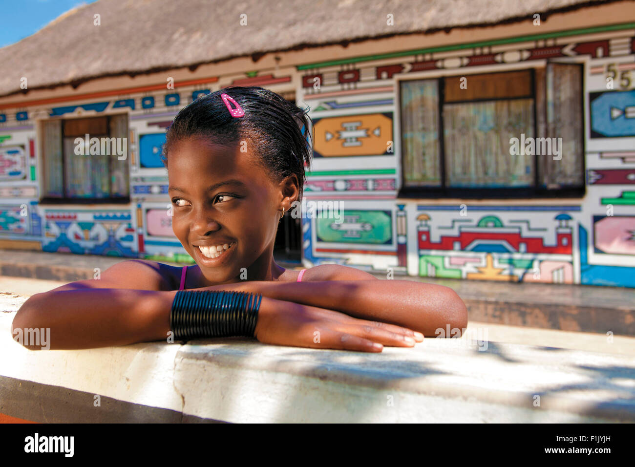 Ndebele houses and young girl Stock Photo