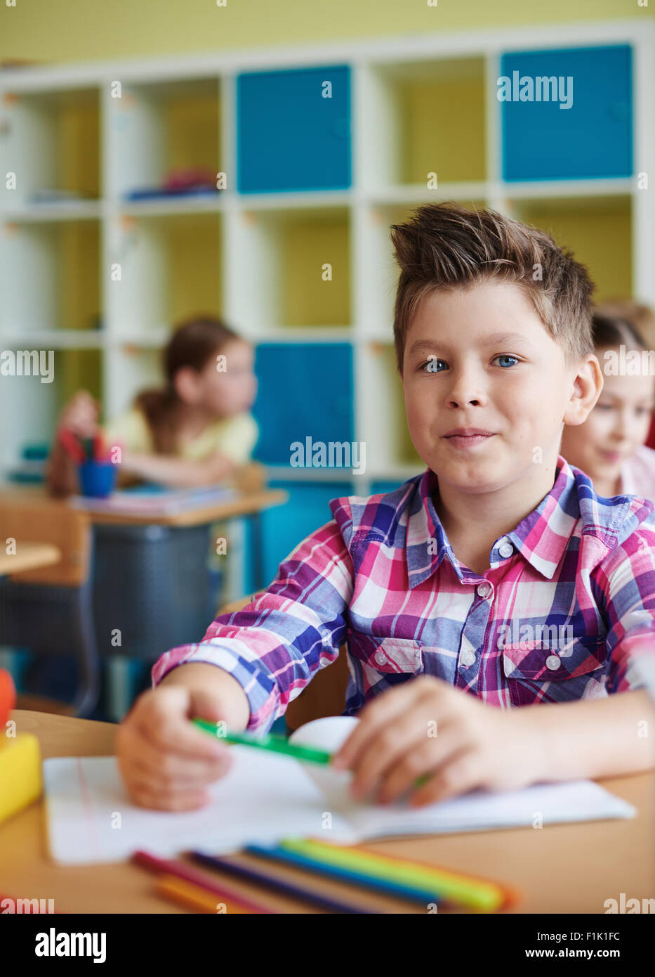 Portrait of a cute schoolboy looking at camera at lesson Stock Photo ...