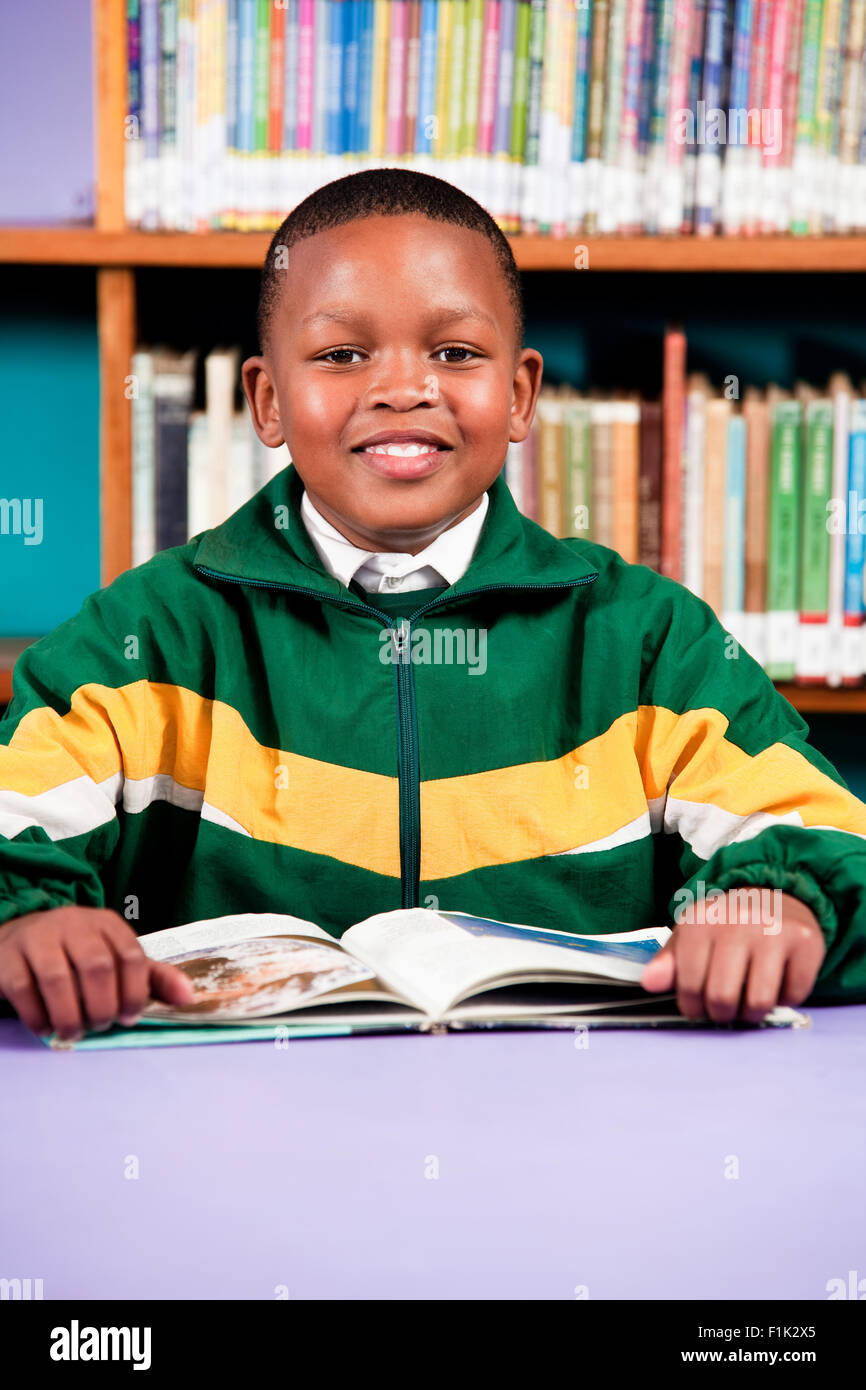 A young boy sitting at a desk with a book, Meyerton Primary School