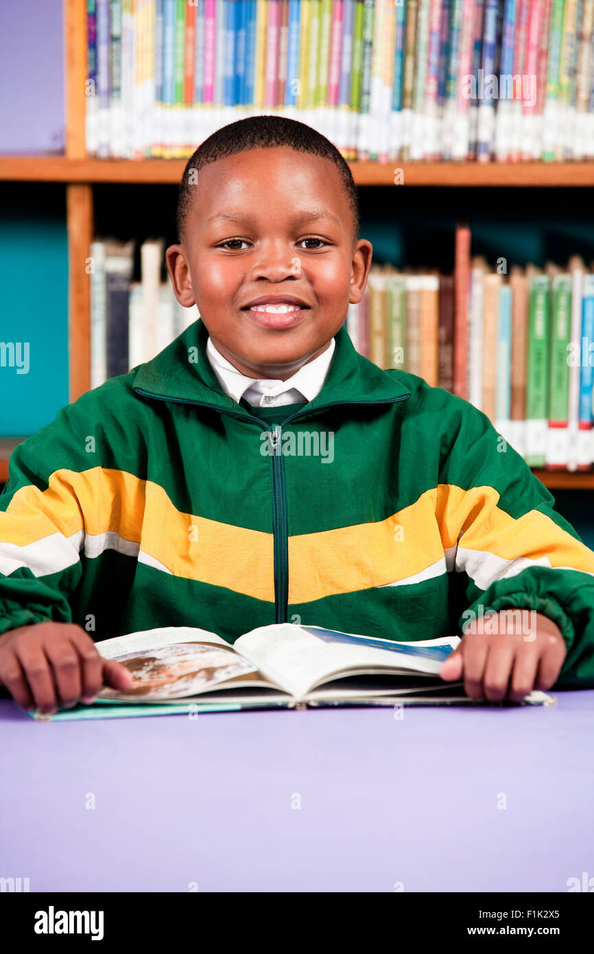 A young boy sitting at a desk with a book, Meyerton Primary School, Meyerton, Gauteng Stock Photo