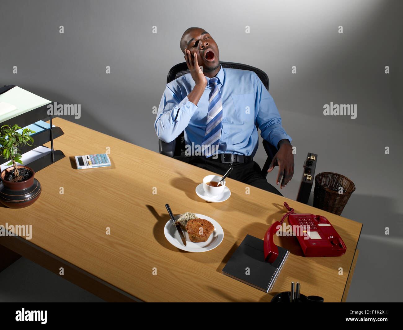 Bored businessman sitting at his desk Stock Photo