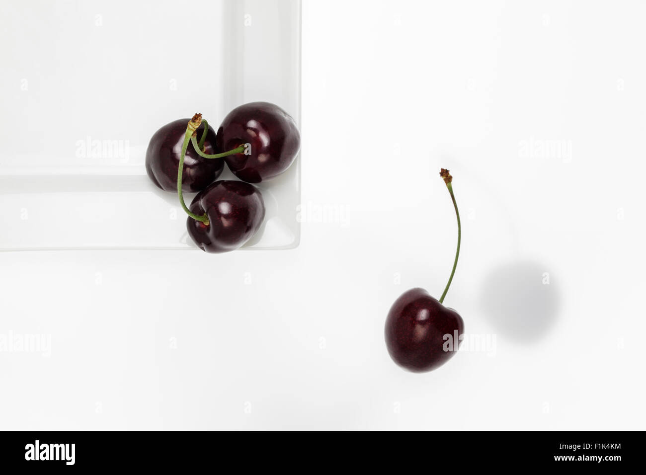 Black cherries on white plate Stock Photo
