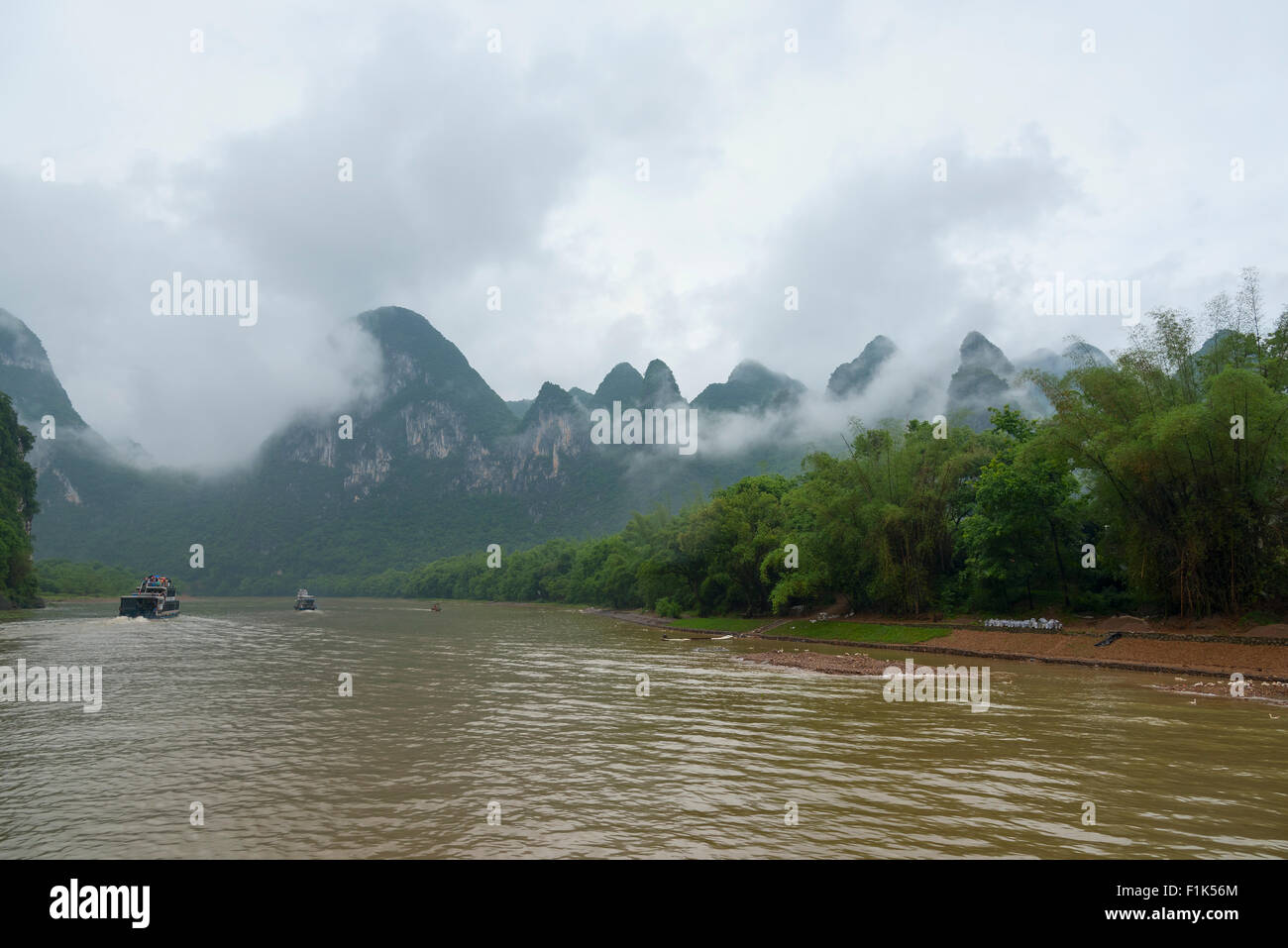 cloudy calcareous mountains and rainforest near River Lee, China Stock Photo