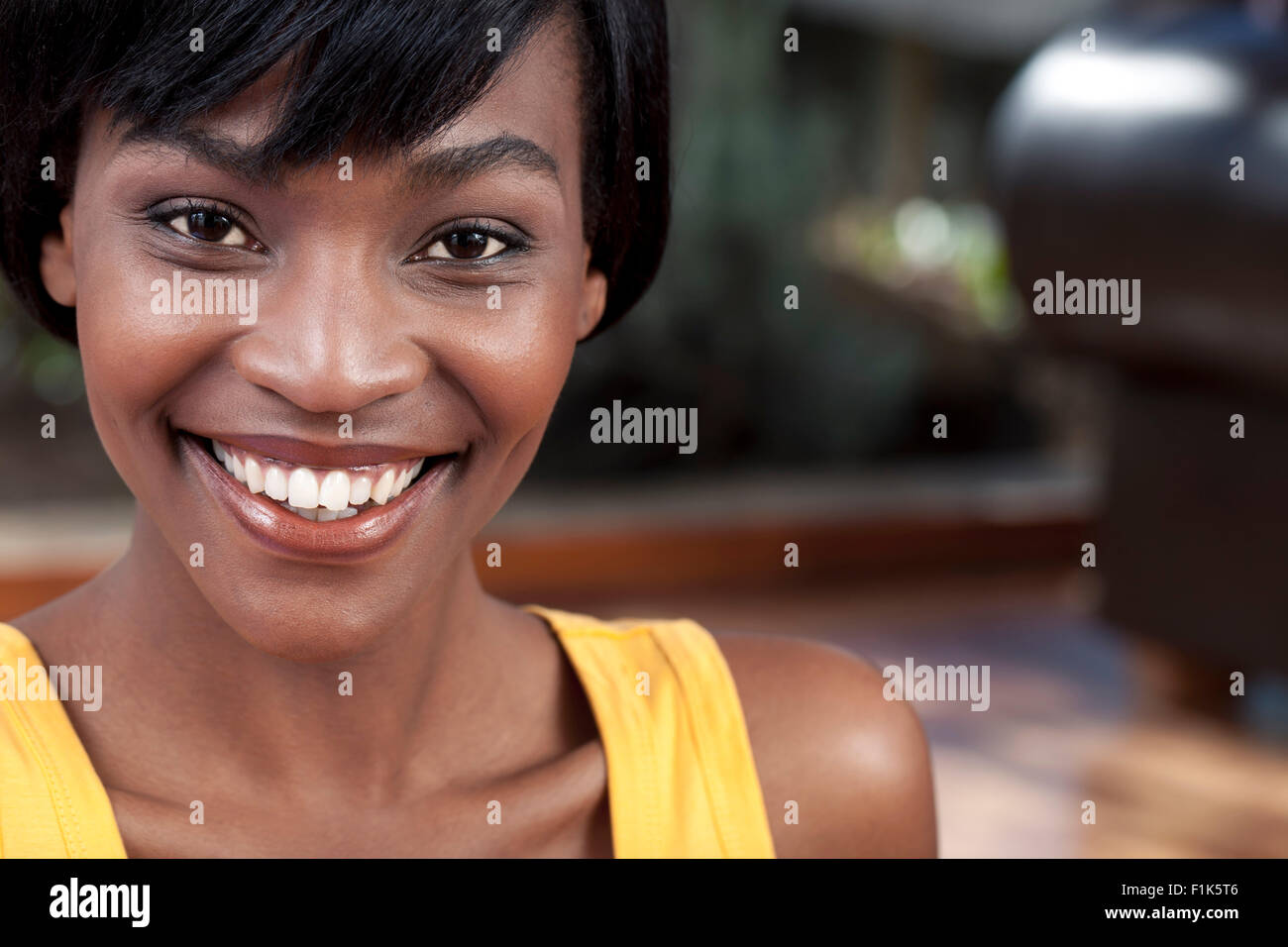 Closeup portrait of young African woman smiling at camera Stock Photo ...