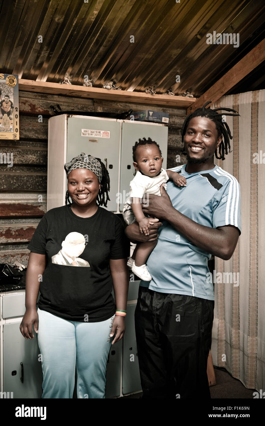 African family stand together inside their rural home, smiling at camera Stock Photo
