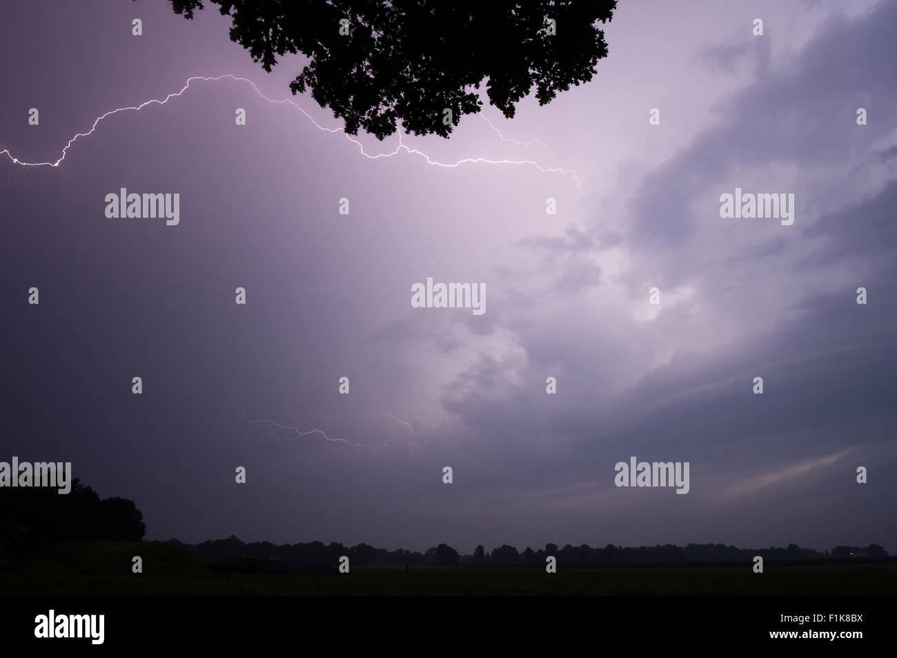 Thunder and lightning at the end of a hot and moistly summer day in the Netherlands Stock Photo