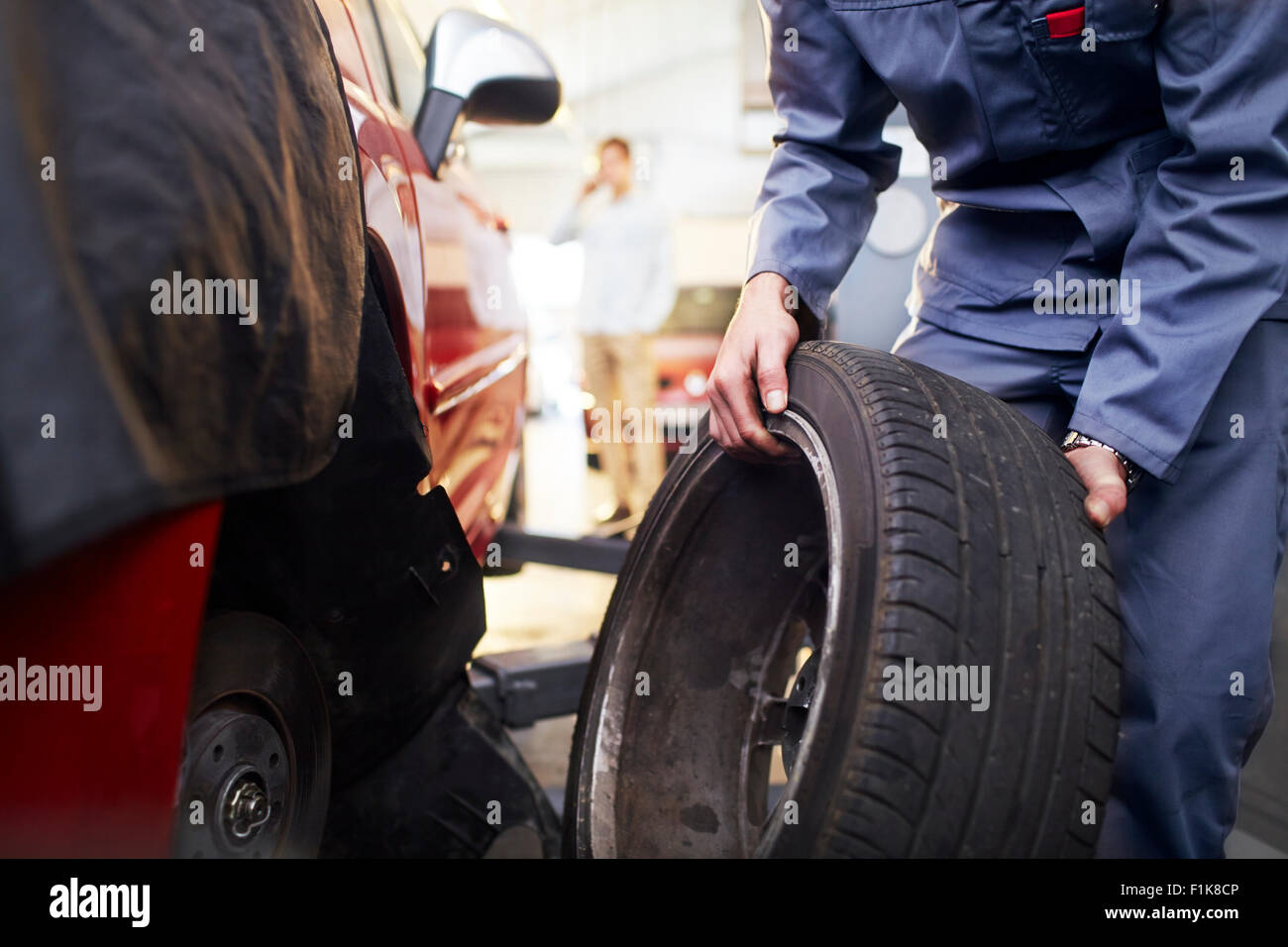 Mechanic replacing tire in auto repair shop Stock Photo - Alamy