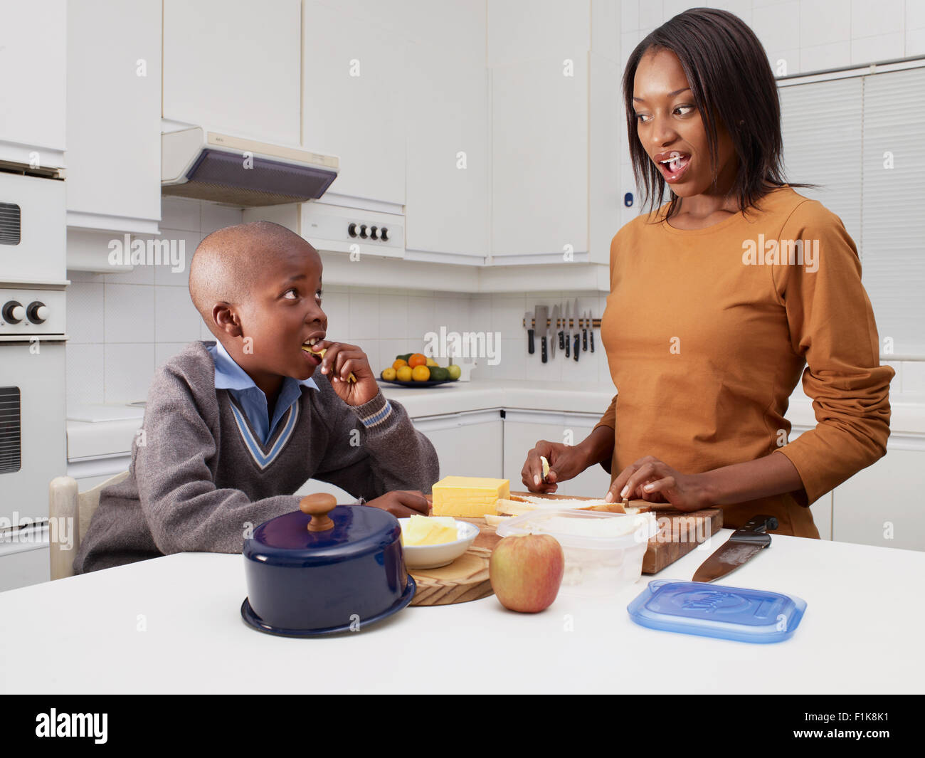 Mother with son (8-9) in kitchen preparing breakfast Stock Photo
