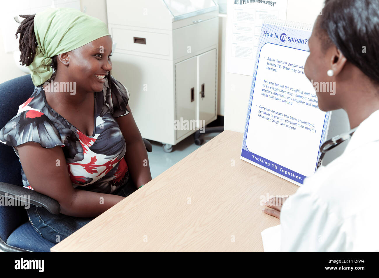 African woman sitting with her doctor for a consultation Stock Photo