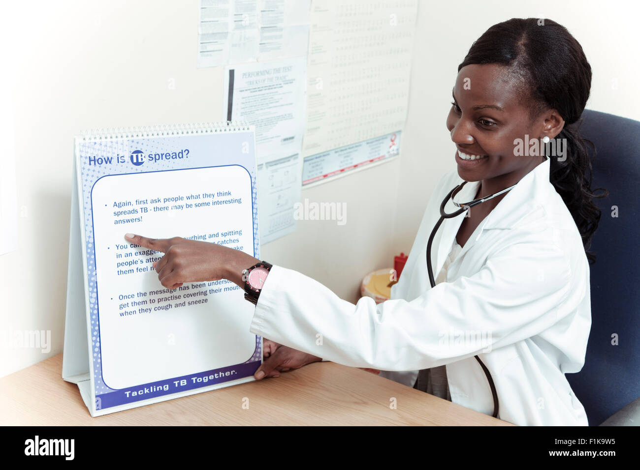 African female doctor explains information to her patients, smiling Stock Photo