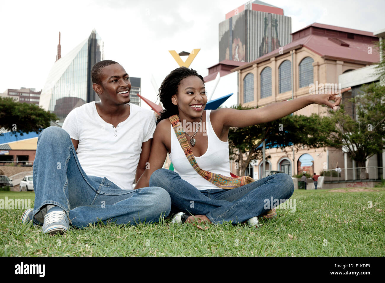 Young African couple sitting in a park, Newtown Johannesburg Stock Photo