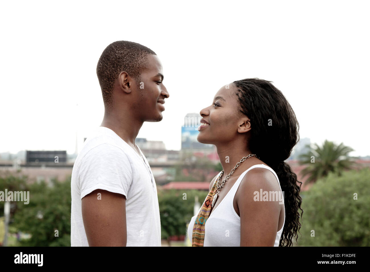 Young African couple standing together with a Johannesburg city scene in the background Stock Photo