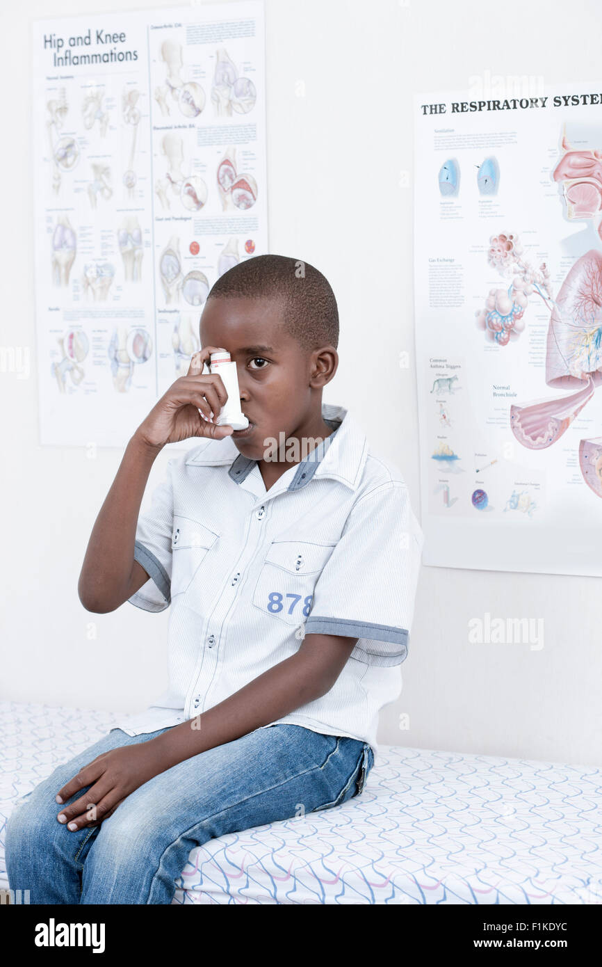 Male African child inhaling an asthma pump inside a doctor's room Stock ...