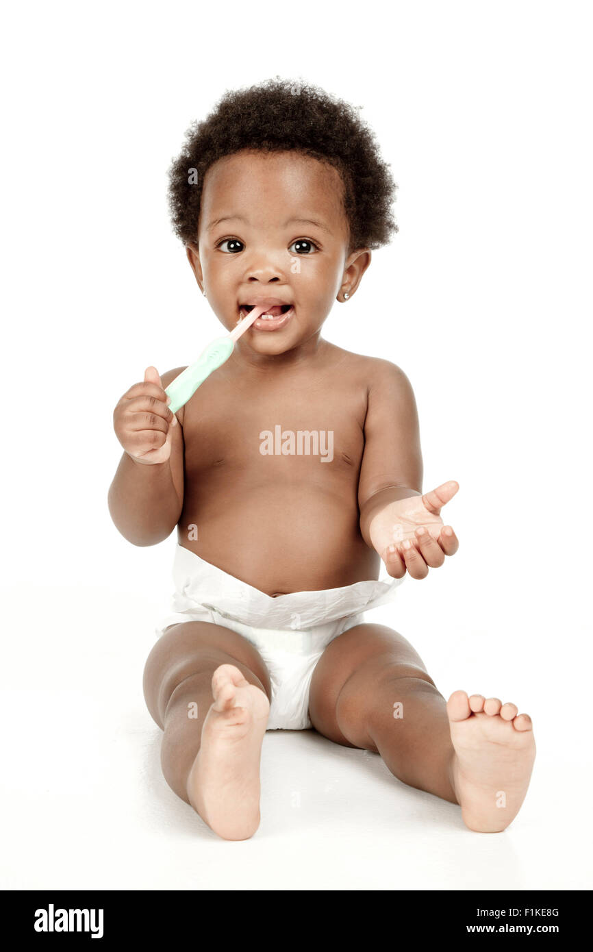 An infant sitting in front of a white background, smiling Stock Photo