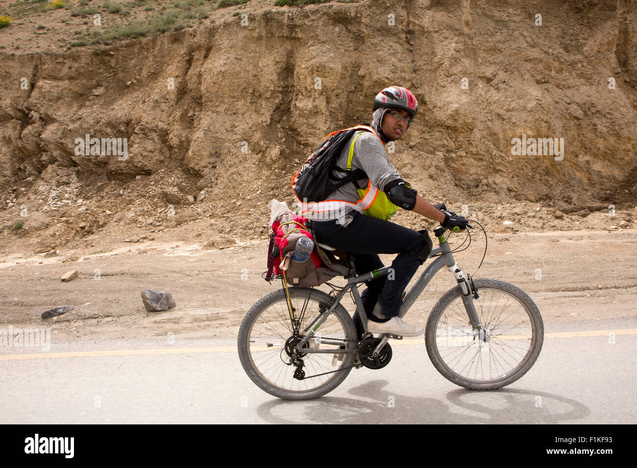 India, Jammu & Kashmir, Kargil to Leh Highway, male Indian cyclist cycling, uphill to Fotu La Pass Stock Photo