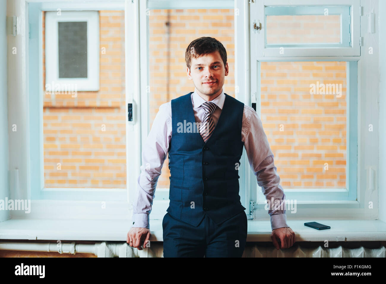 Handsome Caucasian Man In Business Attire Staying In Room Near Window Stock Photo