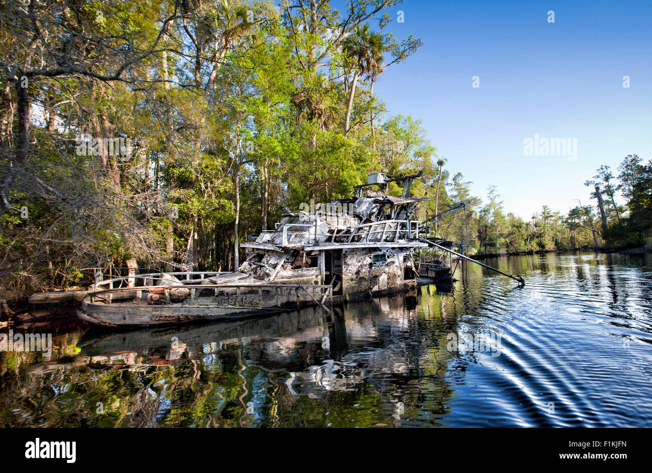 Abandoned boat left sunk along the shoreline of the Waccasassa River in West Central Florida Stock Photo