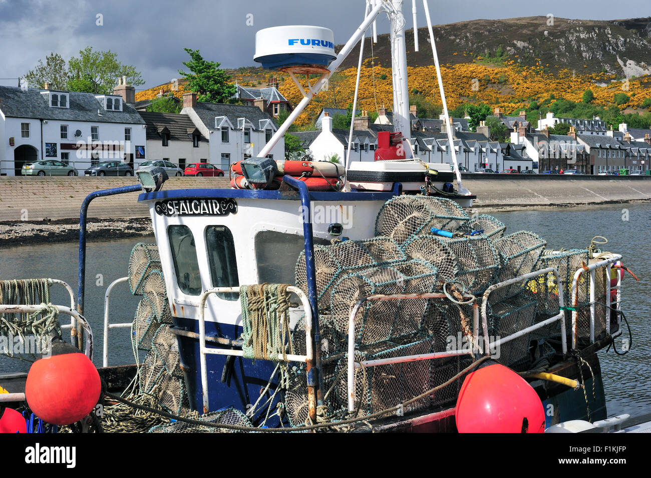 Fishing boat loaded with lobster creels / traps in the Ullapool harbour, Ross and Cromarty, Scottish Highlands, Scotland, UK Stock Photo