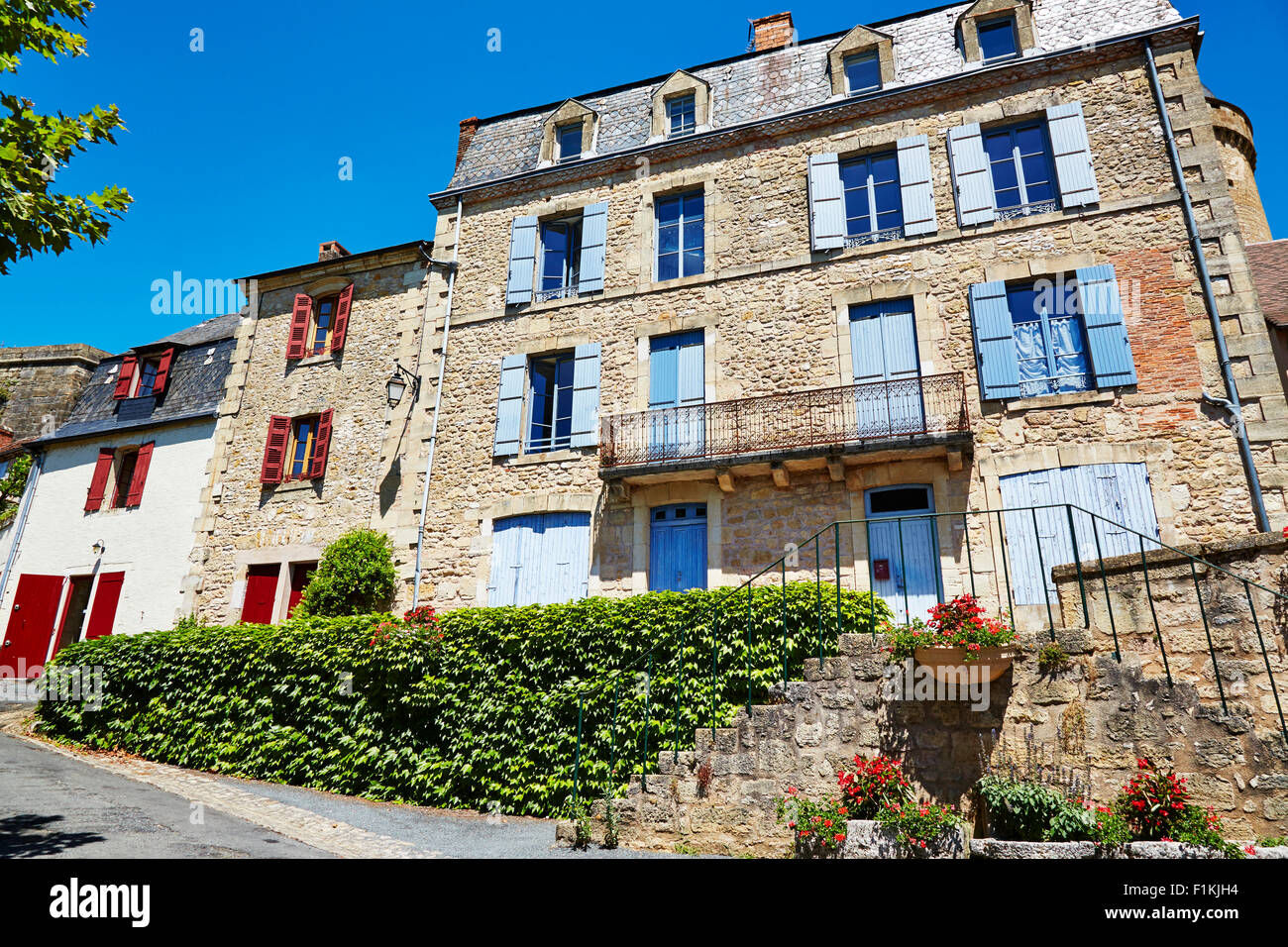 Buildings with colorful shutters in the village of Hautefort, Aquitaine, Dordogne, France. Stock Photo