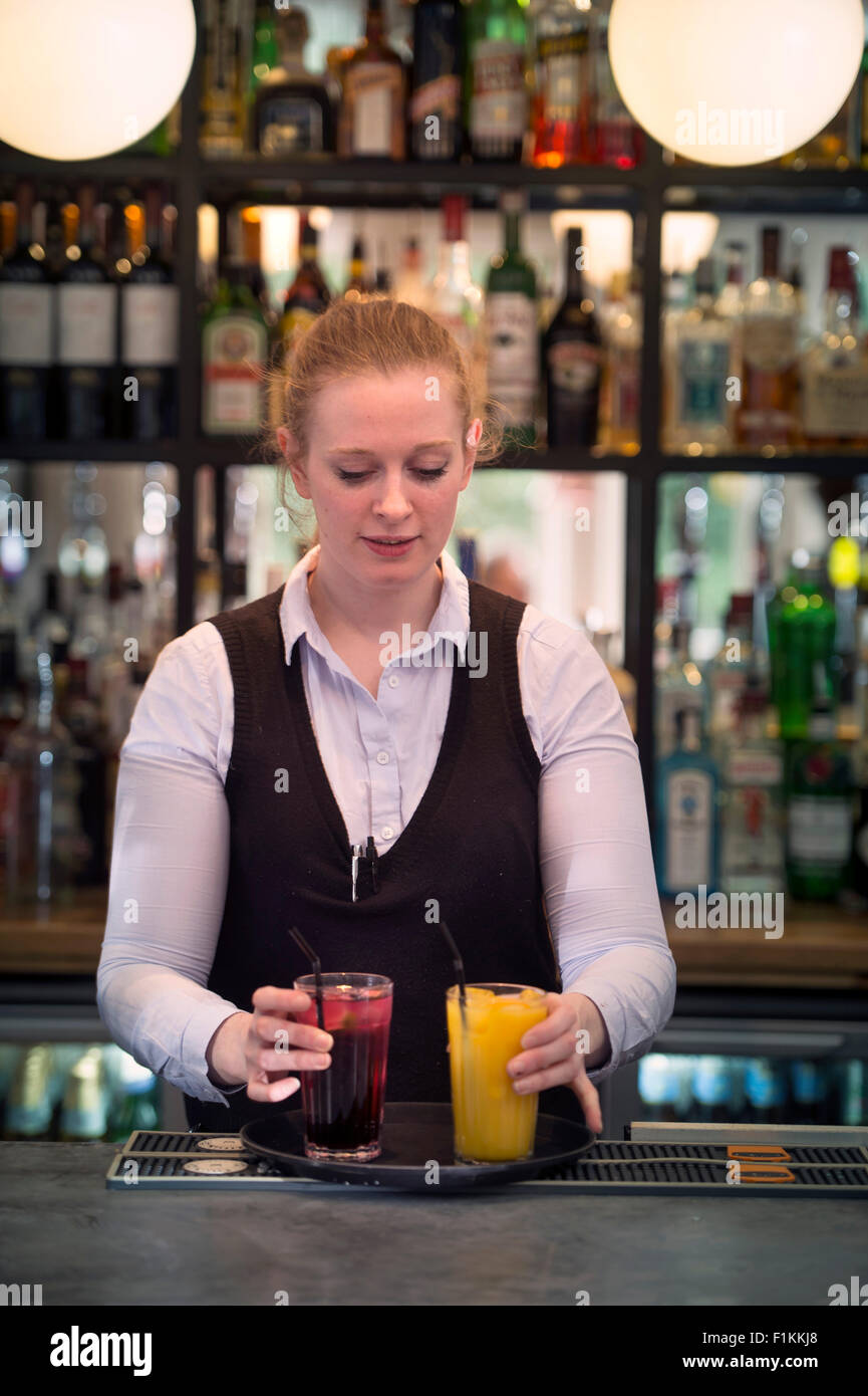 A waitress serves a pair of fruit drinks at a family friendly
