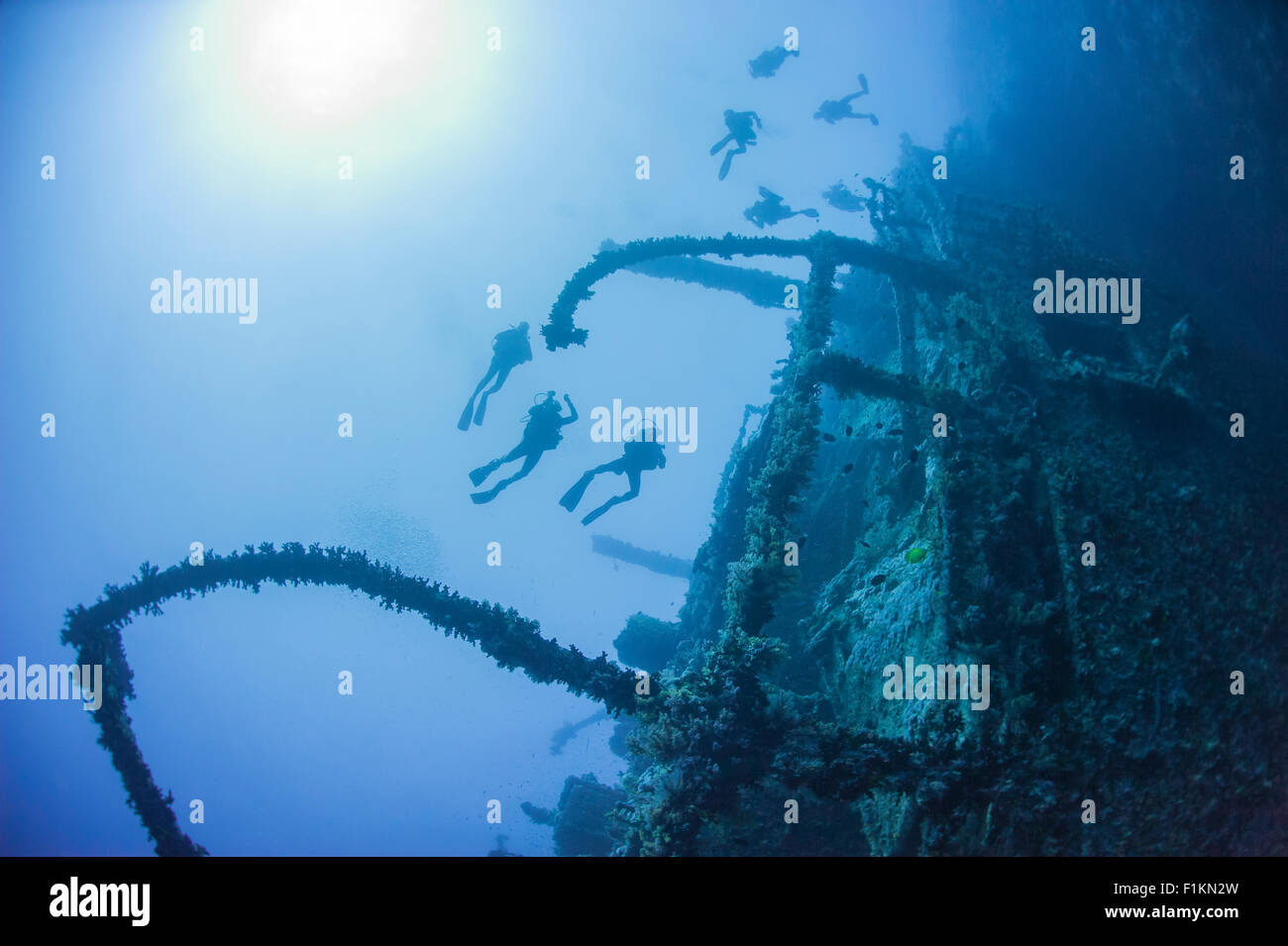 Technical scuba divers exploring a large deep underwater shipwreck Stock Photo