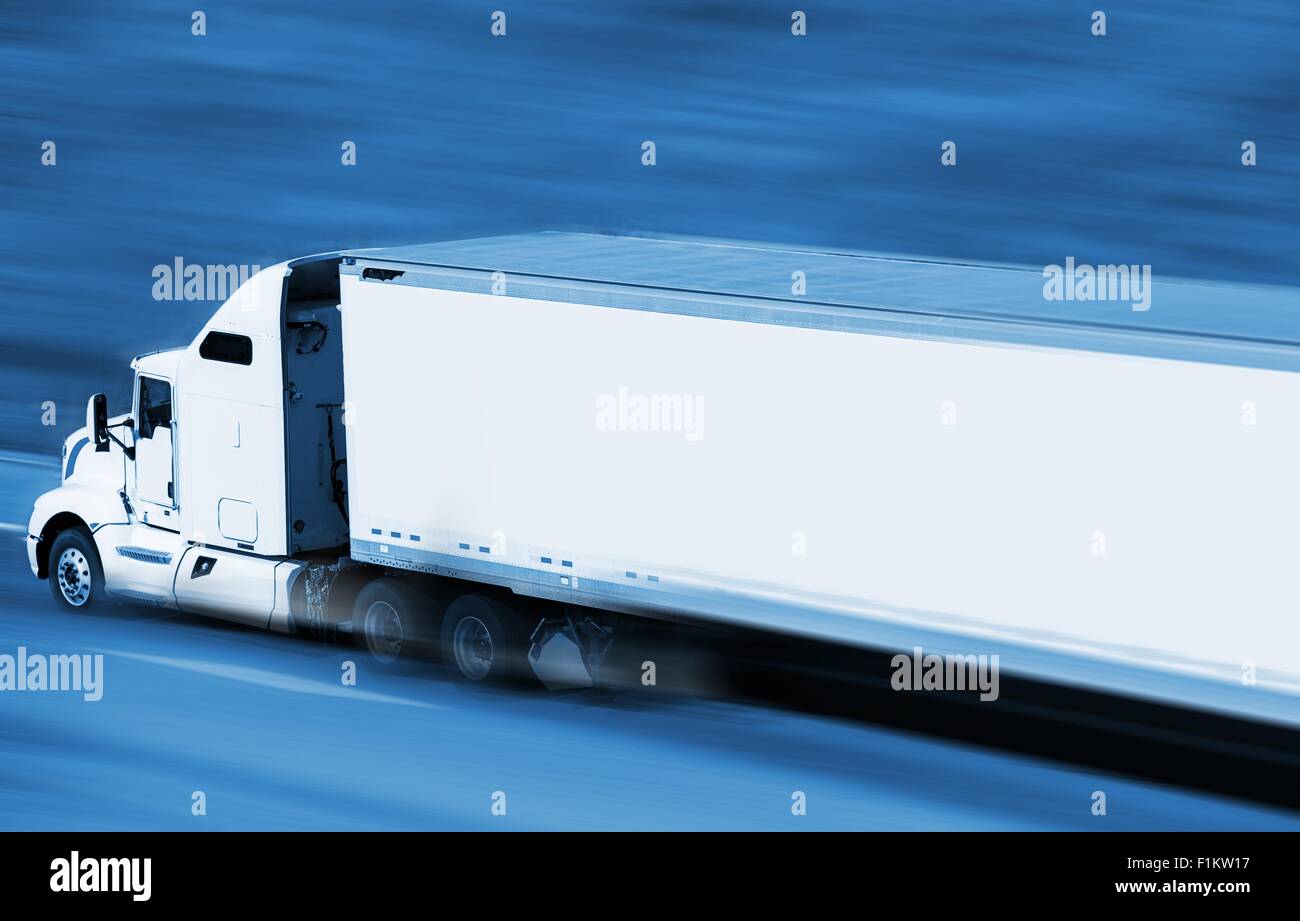 Speeding Semi Truck on the Highway. Blue Color Grading with Motion Blur. Transport and Logistics Concept. Stock Photo