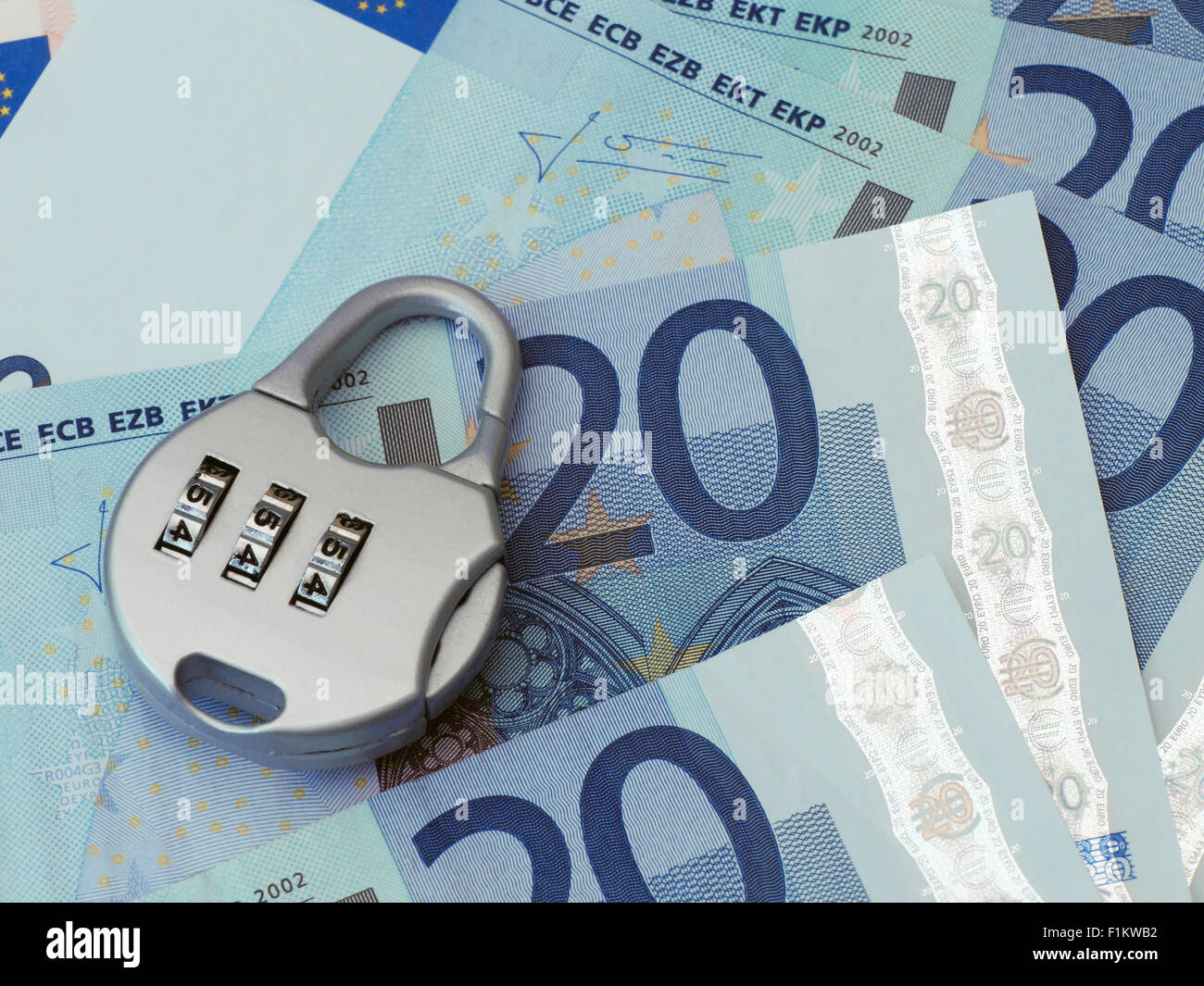 Combination padlock rests on Twenty Euro banknotes Stock Photo