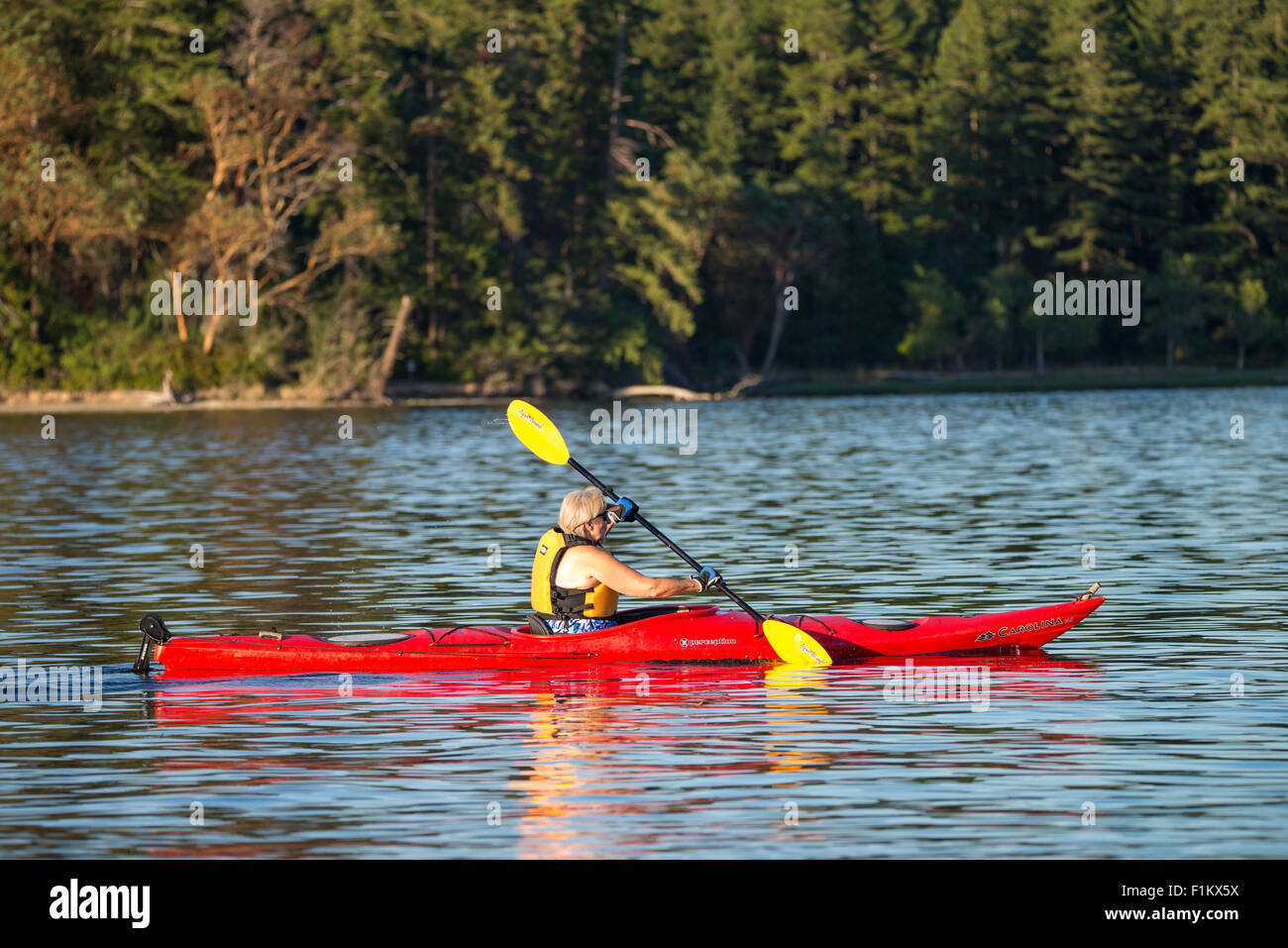 Kayaker paddling red kayak near Hope Island Marine State Park, Puget