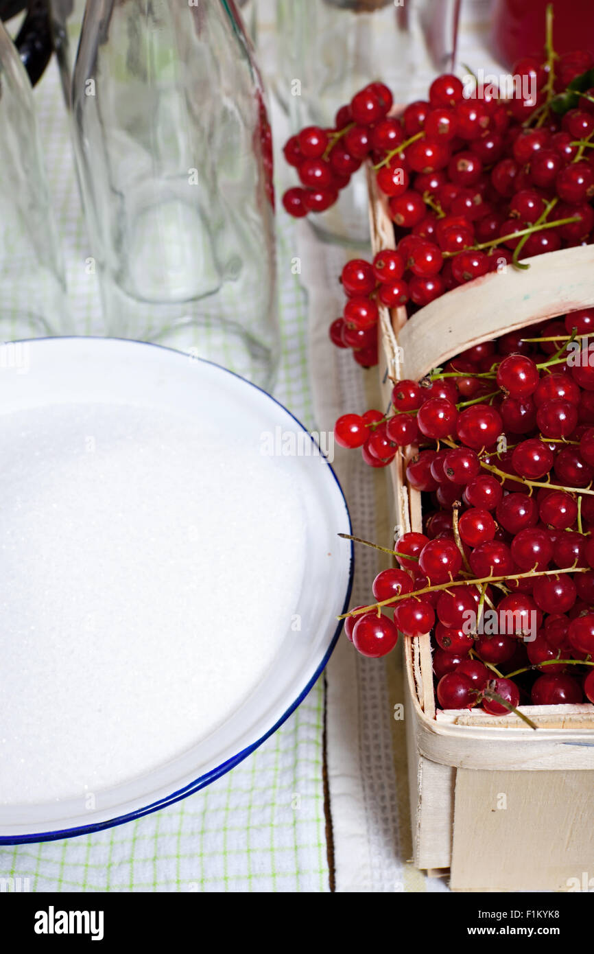 Ripe red currants in a basket with other kitchen utensils for to make syrup itself Stock Photo