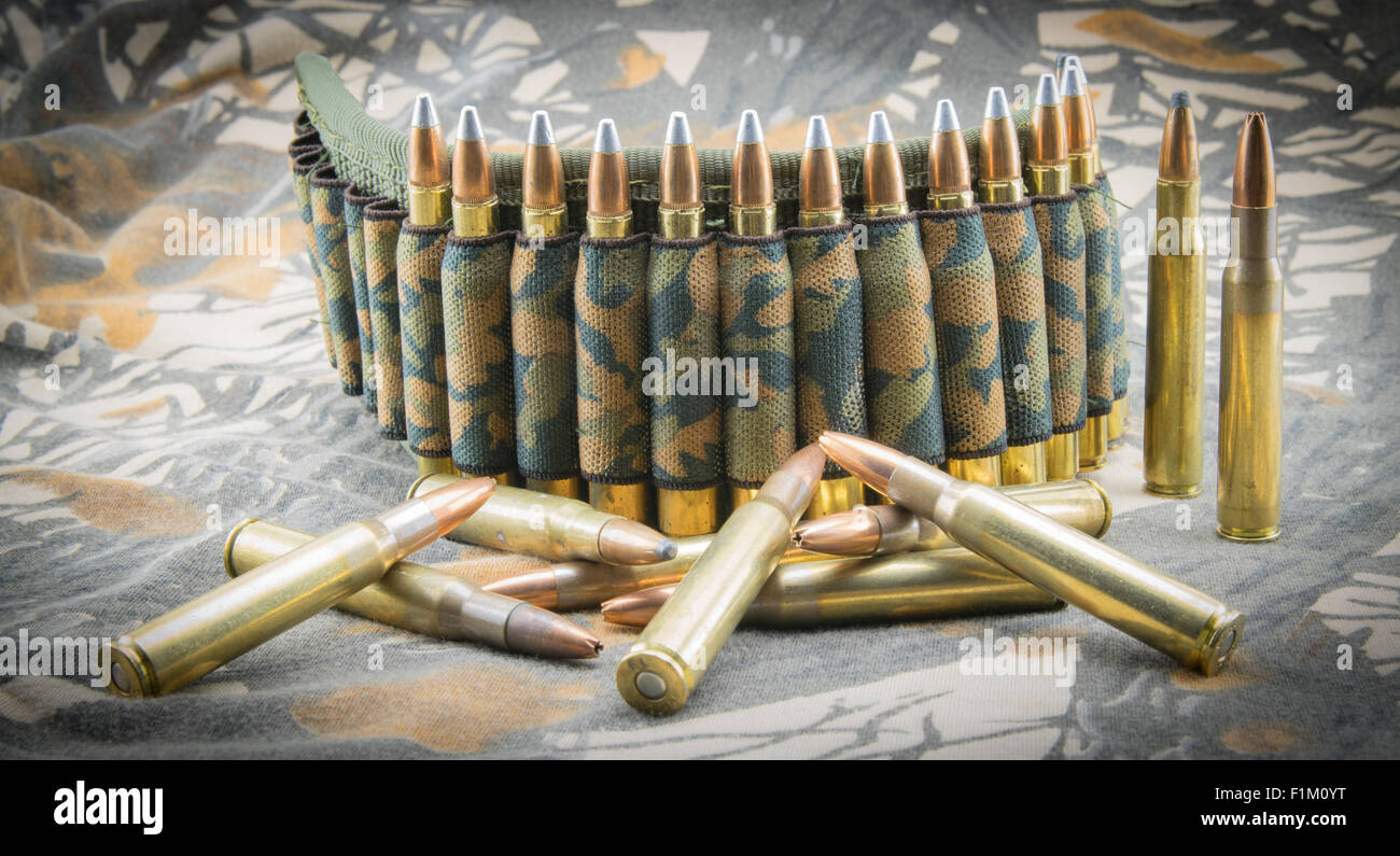 Camouflage ammunition belt for rifle on camouflage background. Stock Photo