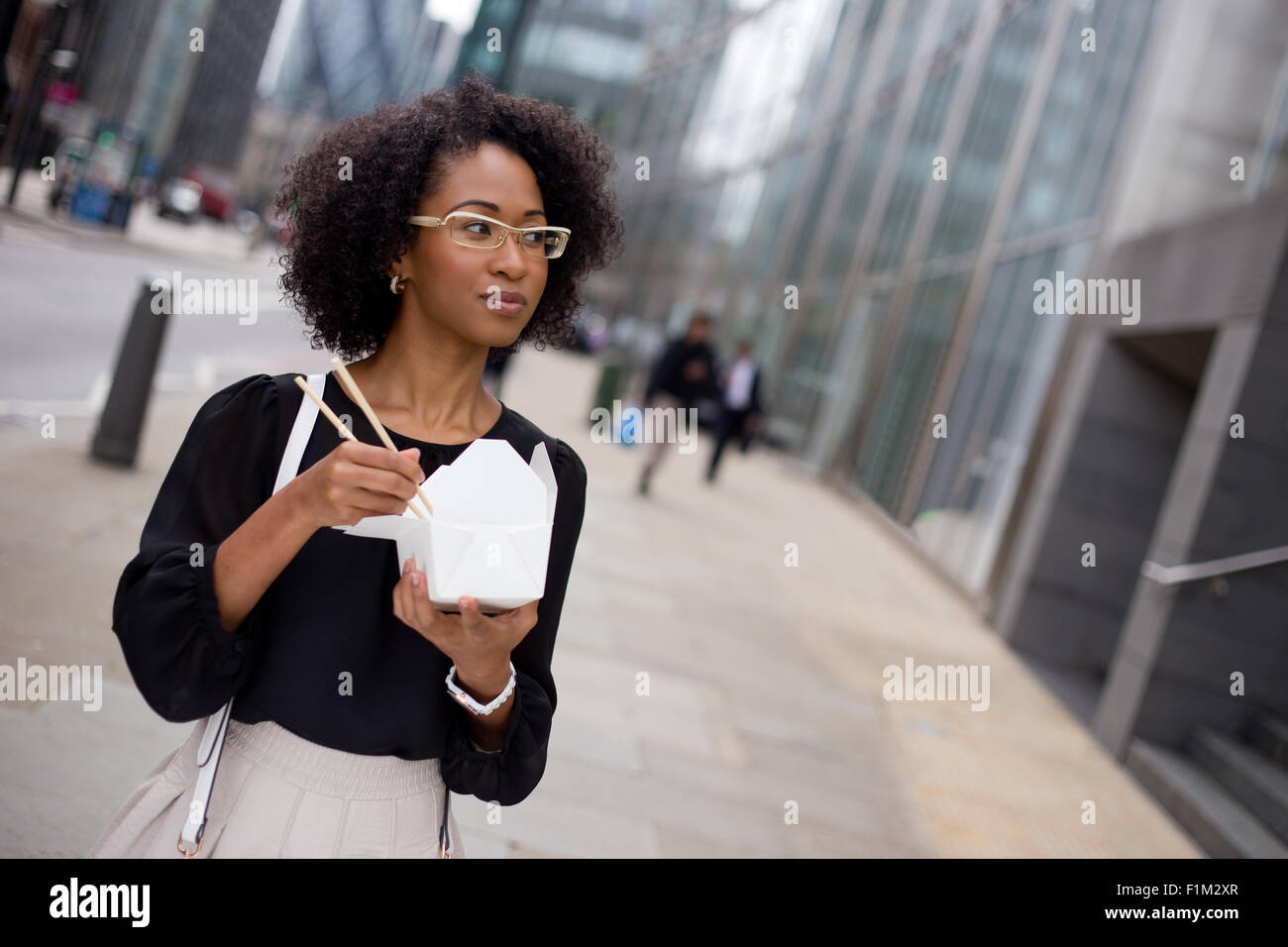young woman eating a take-away in the city Stock Photo