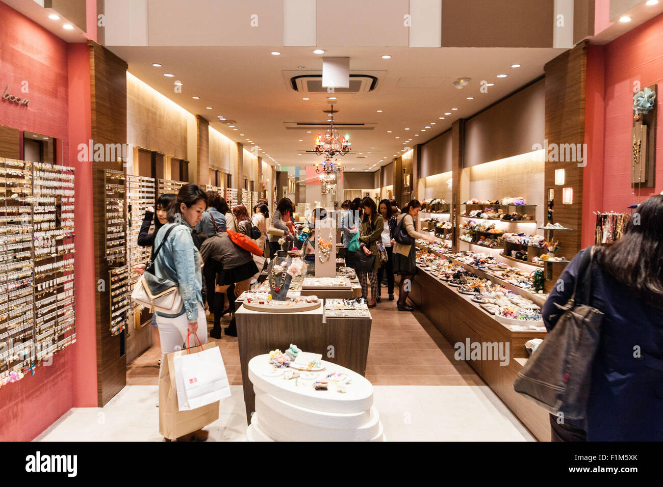 Japan, Osaka, Dotonbori. Interior of women's accessory boutique. View along inside narrow store, with central display and customers shopping Stock Photo - Alamy