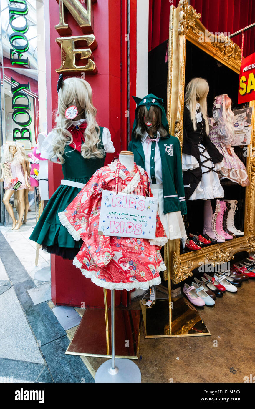 Osaka, Dotonbori. Fashionable boutique with goth and Lolita fashions, three lolita costumes, two schoolgirl with blazer, and pink kids outfit. Stock Photo