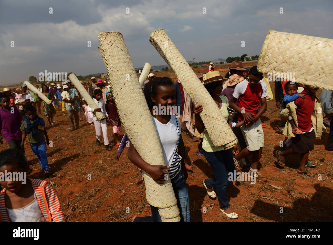 A procession to the tomb. Malagasy people holding mats which will cover the corpses when they are taken out. Stock Photo