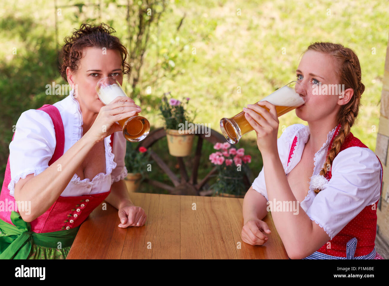 Two attractive Bavarian women drinking beer Stock Photo