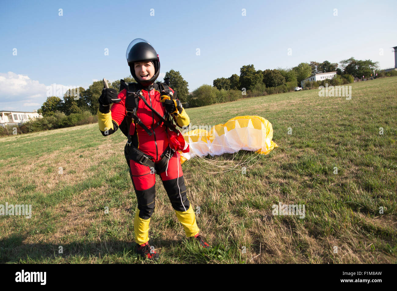 Freefly skydiver girl landed with her parachute and she is now very happy to be save back on the ground. Stock Photo