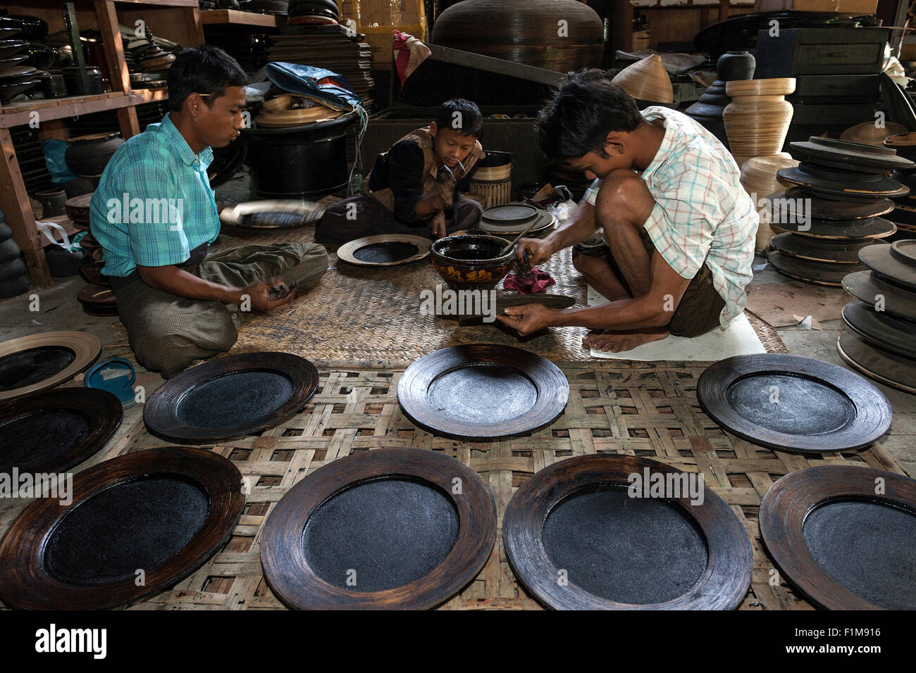 Manufacture of lacquerware, local men priming objects for lacquerware, Bagan, Mandalay region, Myanmar Stock Photo