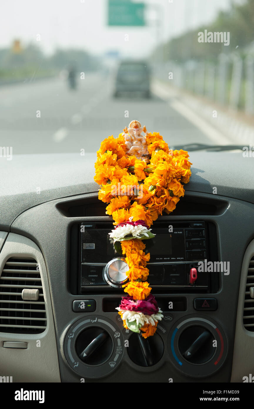 Uttar Pradesh, India. Agra to Delhi. Ganesh on dashboard with garland of marigolds. Stock Photo