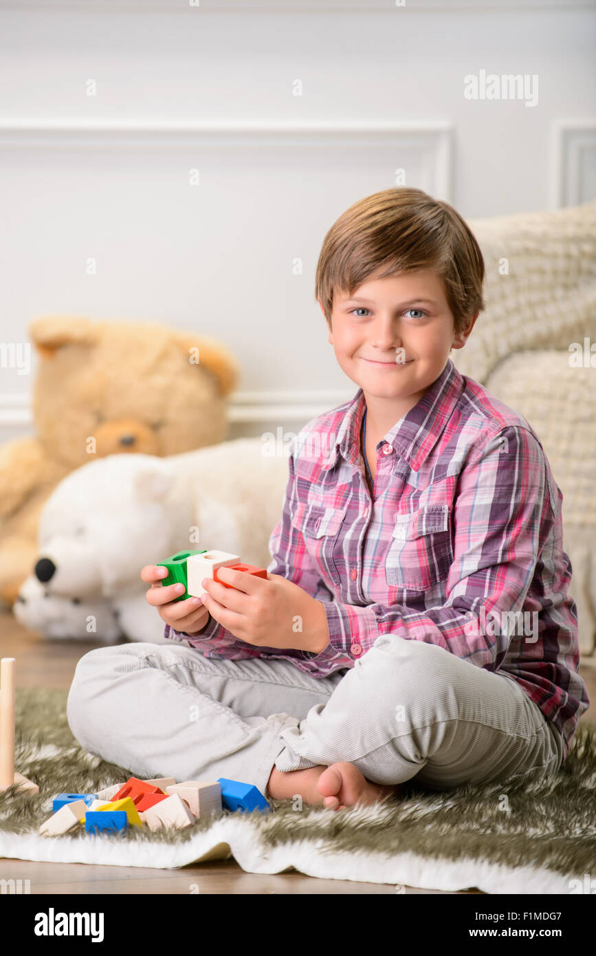 Cheerful boy playing on the carpet Stock Photo - Alamy