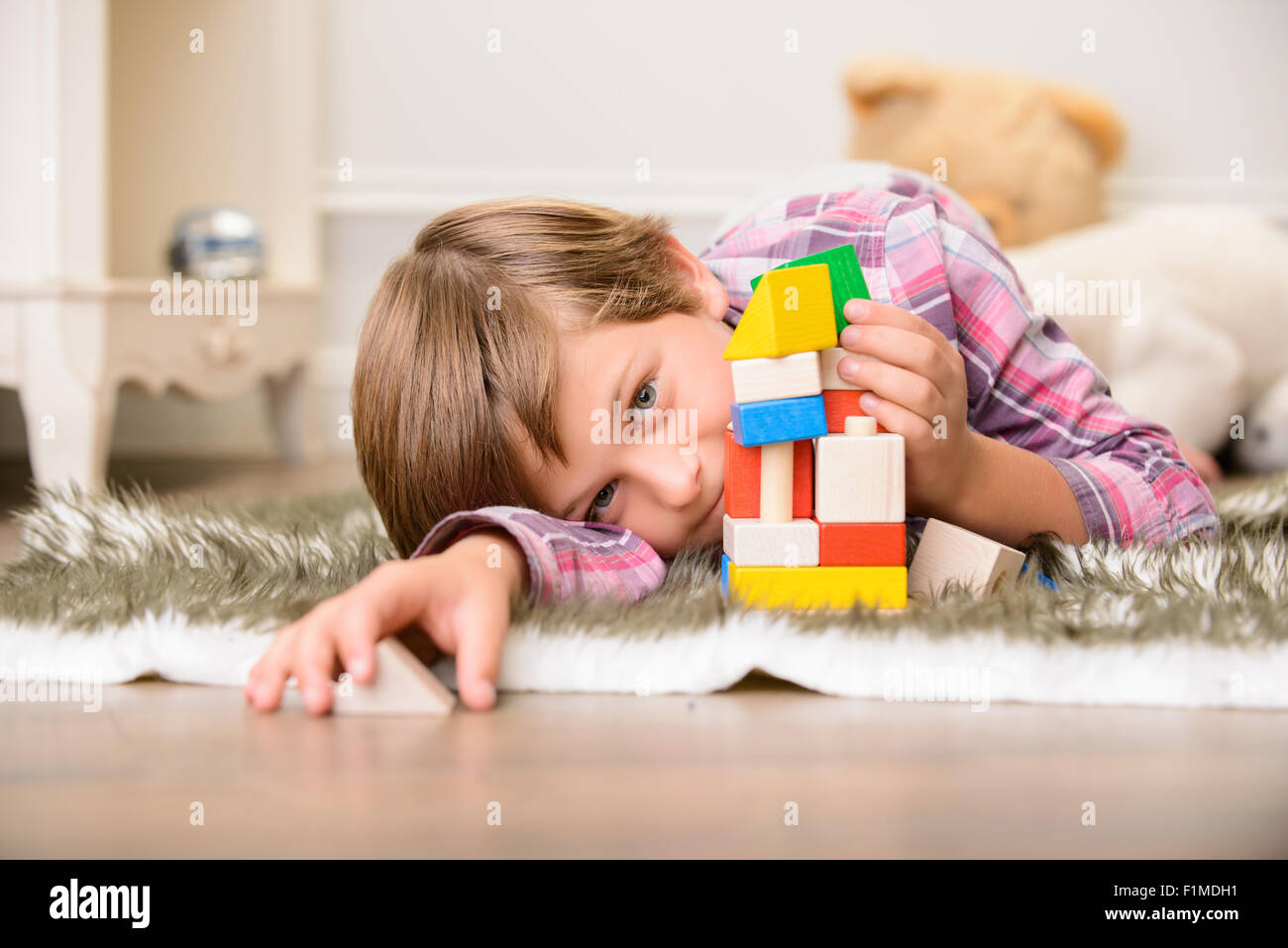 Cheerful boy playing on the carpet Stock Photo - Alamy