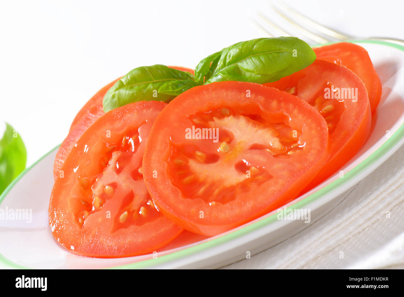 detail of tomato salad with basil on white plate Stock Photo - Alamy