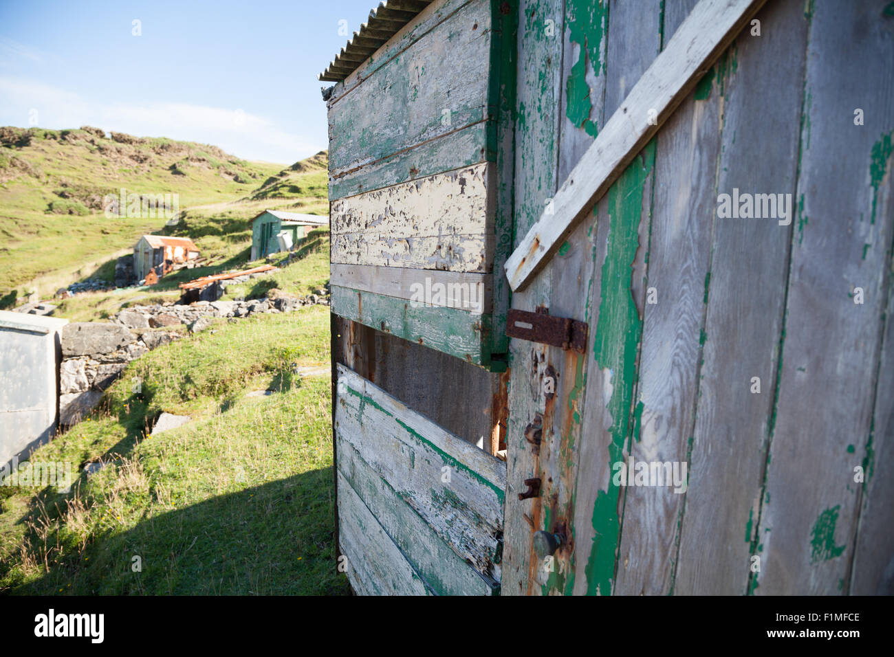 Abandoned fishing huts at Porth Ysgaden, Tudweiliog, Llyn Peninsula, North Wales with missing side and wooden cladding Stock Photo