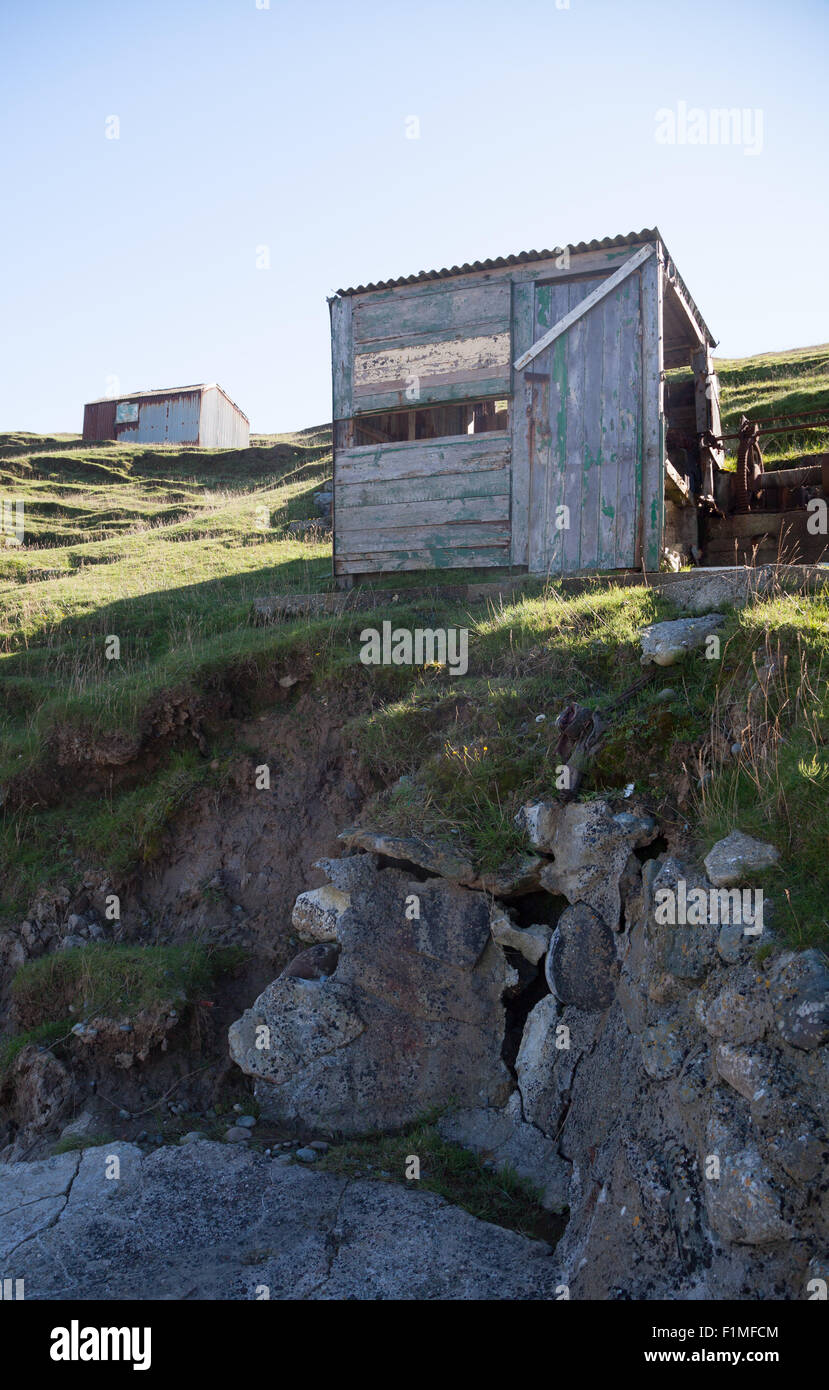 Abandoned fishing huts at Porth Ysgaden, Tudweiliog, Llyn Peninsula, North Wales with missing side and wooden cladding Stock Photo