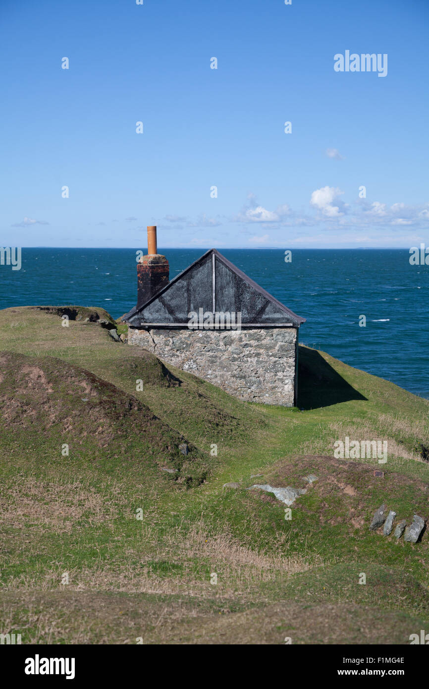 An abandoned fishing hut on a clifftop at Porth Ysgaden, Tudweiliog, Llyn Peninsula, North Wales with blue sea and sky Stock Photo