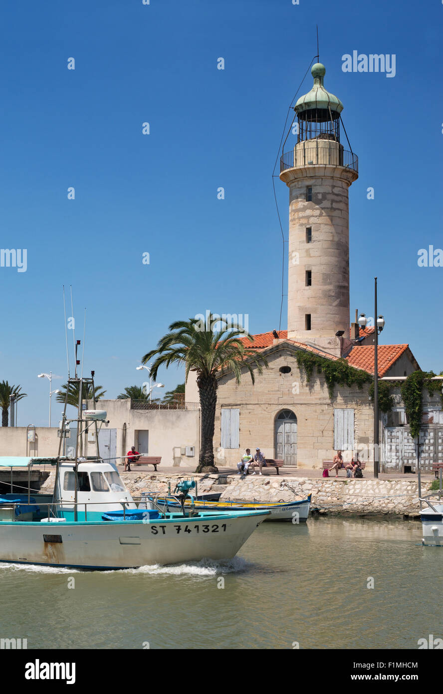 Fishing boat passing lighthouse, Le Grau-du-Roi, Languedoc-Roussillon, France, Europe Stock Photo