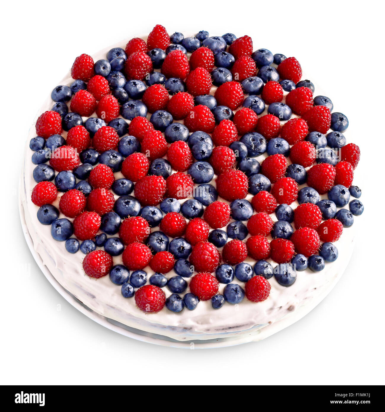 Creamy sweet cake with chocolate and cream, garnished with blueberries and raspberries on a white tablecloth Stock Photo