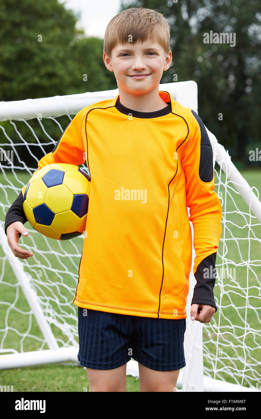 Portrait Of Goal Keeper Holding Ball On School Soccer Pitch Stock Photo