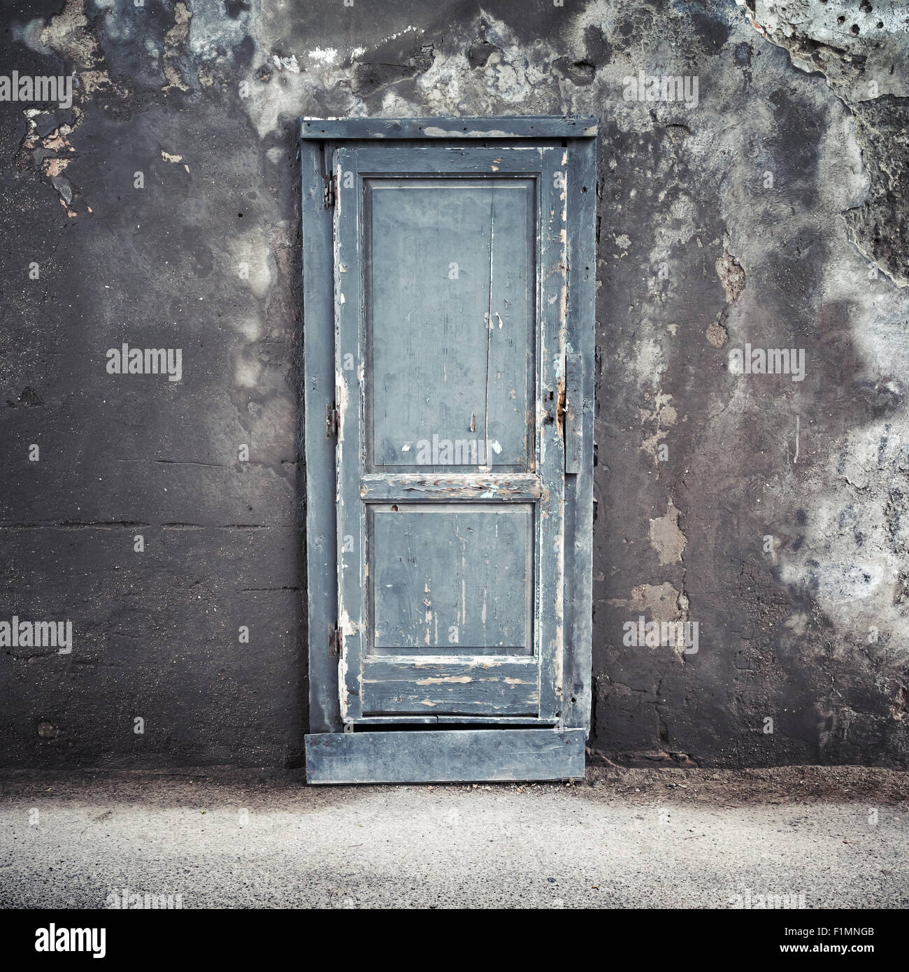 Old blue wooden door in dark concrete wall, empty abstract interior, square background texture Stock Photo